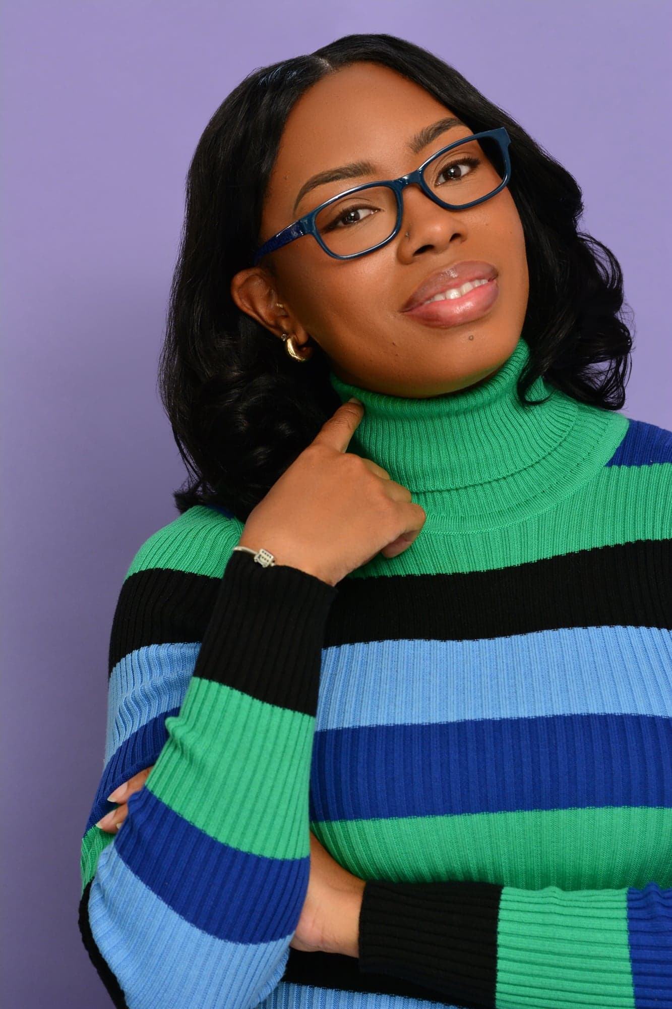 Michelle Renée Gomes headshot, glasses and striped turtleneck